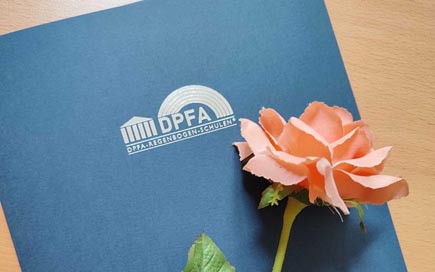 rosa Rose auf blauer Zeugnismappe mit DPFA-Logo