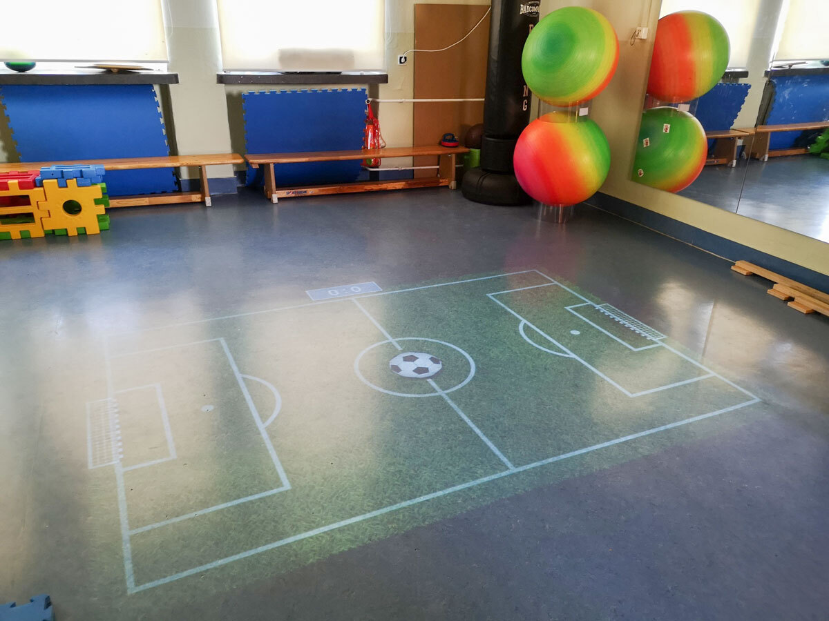 Bewegungsraum mit digitalem, fliegendem Teppich für virtuelles Spielen und Lernen in der Grundschule der DPFA-Regenbogen-Schulen Rabenau