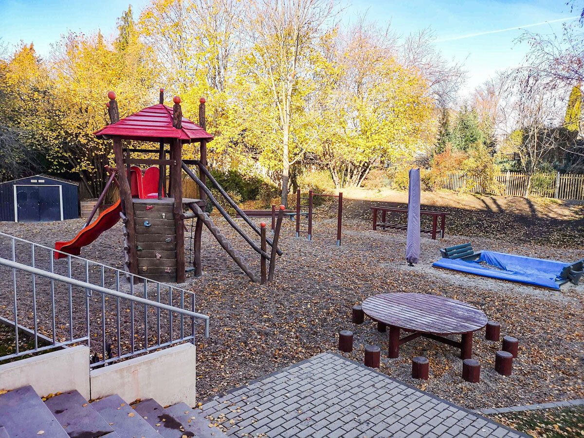 Spielplatz mit Rutsche, Klettergeräten, Sitzgelegenheit und Sandkasten in der Grundschule der DPFA-Regenbogen-Schulen Rabenau.