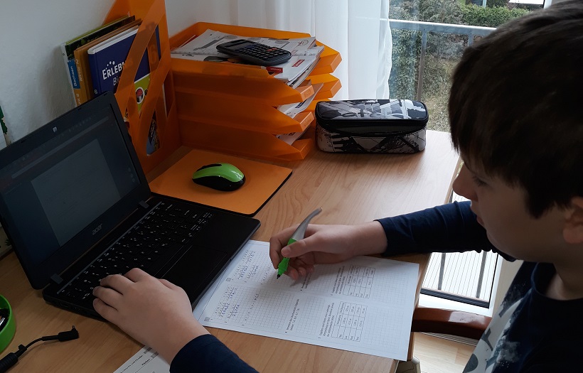 Oberschüler der DPFA Rabenau lernt zu Hause. Er sitzt an seinem Schreibtisch vor einem Laptop und löst Aufgaben auf einem vorgedrucktem Blatt.