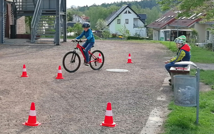 Kind auf einem Fahrrad absolviert einen Parcours